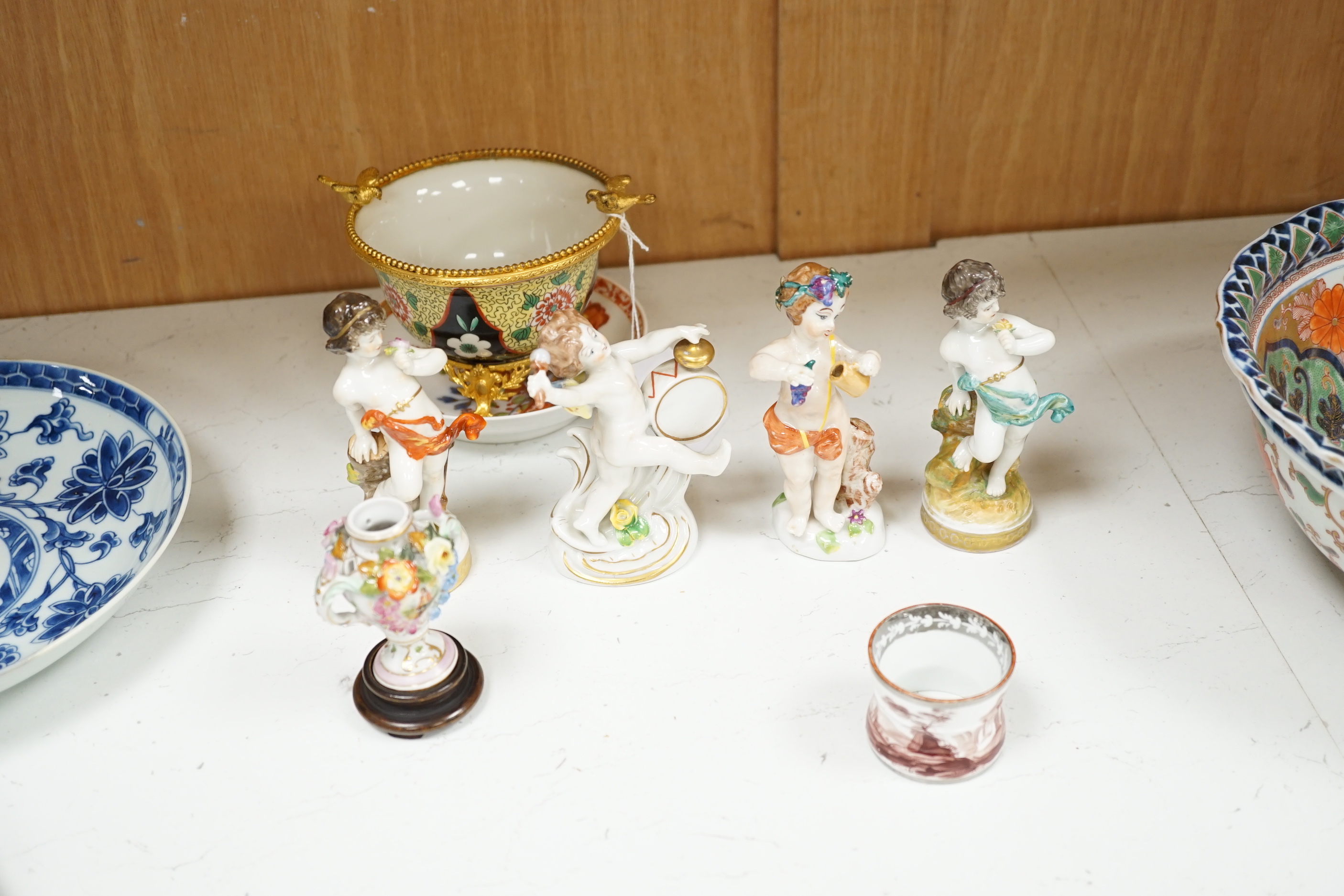 Continental porcelain: four putti ornaments, a Staffordshire dog, green leaf plate, a napkin ring 18th century jug etc (15)